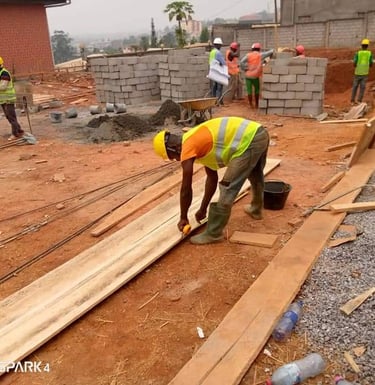 Construction workers in safety vests and hard hats building a residential structure with concrete blocks.