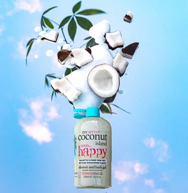 Treaclemoon Coconut Island shower gel with floating coconut pieces against a blue sky