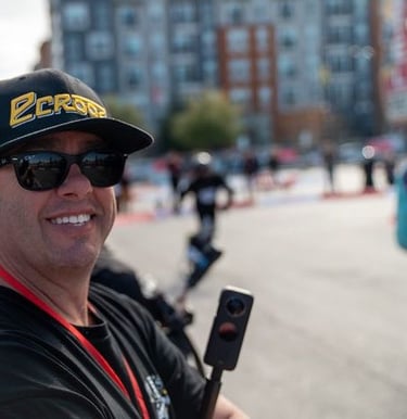 a man in a black hat and sunglasses is holding a cell phone