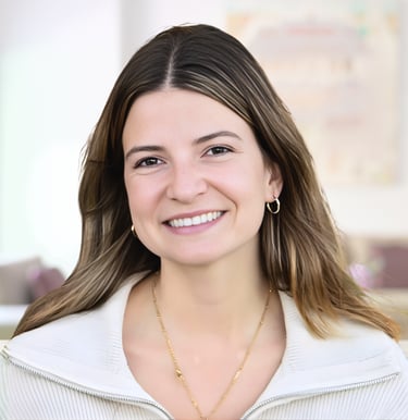Smiling woman with light brown hair wearing a white sweater and gold jewelry in a professional portrait.
