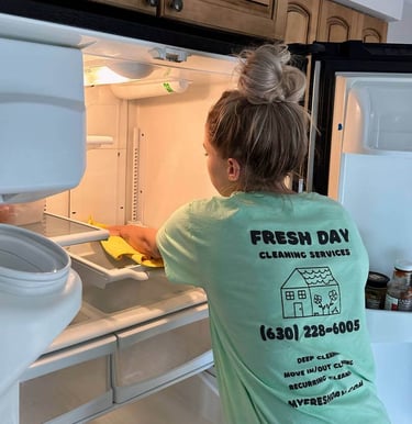 a cleaner in a uniform shirt is clean the refrigerator