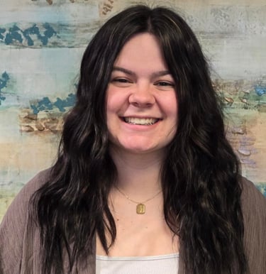 a woman with long hair and a brown jacket