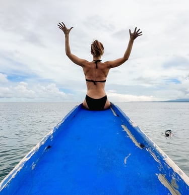 a man sitting on a boat in the ocean