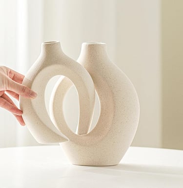 Minimalist interlocking cream ceramic vase set on a white table for modern home decor.