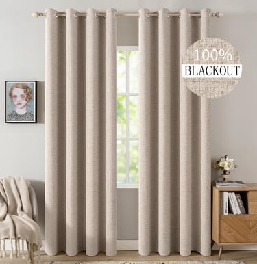 Beige textured blackout curtains hanging on a wooden rod in a modern bedroom interior.