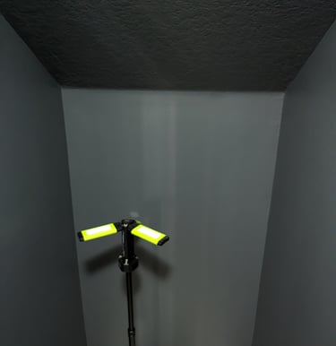 An under staircase half-bath painted charcoal grey in preperation for an interior mural.
