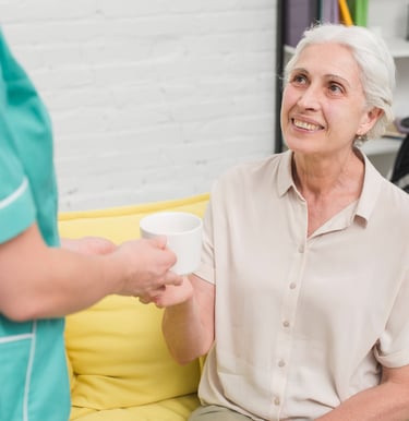 a caregiver reminding a senior woman to take her medicines