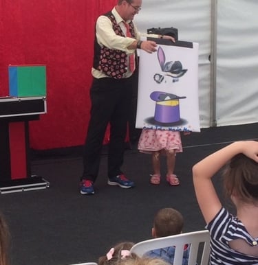 Cardiff Magician Carl The Magician performing a magic trick with a "rabbit in a hat" for an audience