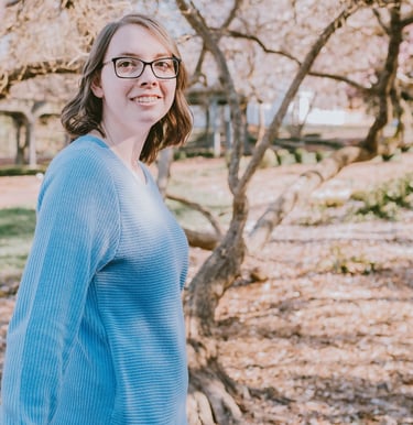 a woman in glasses and a blue sweater