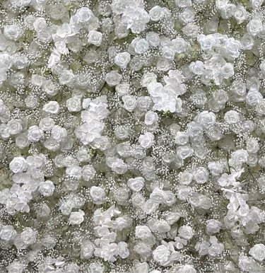 Elegant floral backdrop featuring a dense arrangement of white roses and baby's breath for wedding decor.