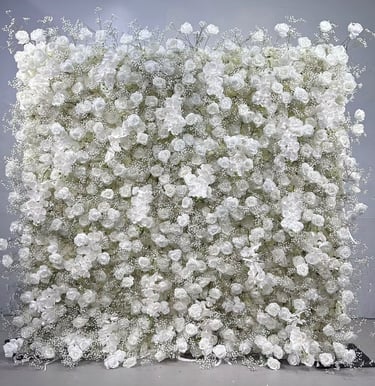 Elegant wedding backdrop featuring a dense wall of white roses and delicate baby's breath flowers.