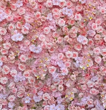 Floral backdrop featuring a dense arrangement of light pink roses and orchids for event decor.