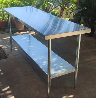 Large stainless steel catering table with under shelf, available for table hire.