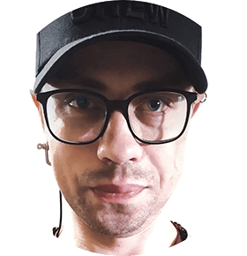 Photo of a man's face with glasses and a black cap on his head