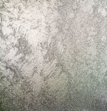 A cool silver paint sample showing off its shimmering grainy texture.