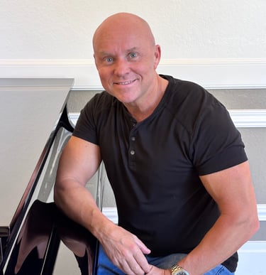 Composer Mark Bulmer sitting at the piano