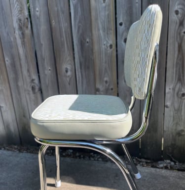 newly reupholstered vintage kitchenette chair with patterned vinyl and polished chrome legs