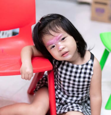 a little girl with a pink face paint on her face