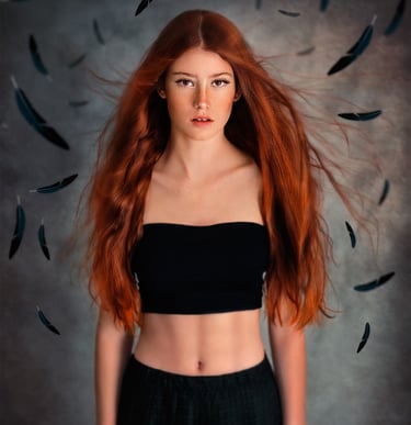 red head girl with freckles, wearing black skirt and crop top. Black feathers around her