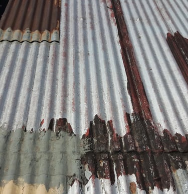 Advanced corrosion and material failure on metal roofing, example of roof beyond repair stage