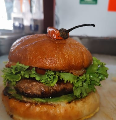 Hamburguesa de ternera gourmet con lechuga fresca y un chile a la parrilla en un pan brioche tostado