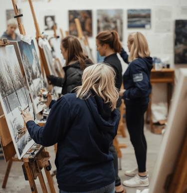 a group of people standing around a painting