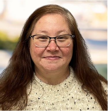 a woman with glasses and a sweater on