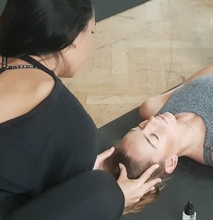 Yogalehrerin begleitet Schülerin in Savasana – persönliche Einzelstunde mit achtsamer Berührung