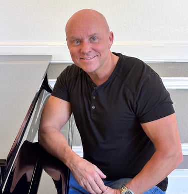 Composer Mark Bulmer sitting at the piano