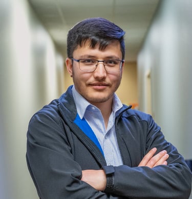 a man in a jacket and button down shirt is standing in a hallway