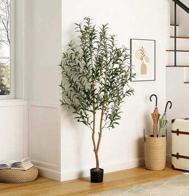 A tall artificial olive tree in a black pot decorating a bright modern living room corner.