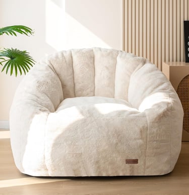 Cream plush faux fur bean bag chair in a modern living room setting.