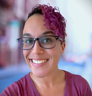 a woman with glasses and a purple shirt
