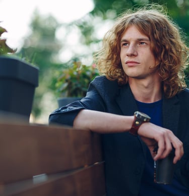 a man sitting on a bench in a park