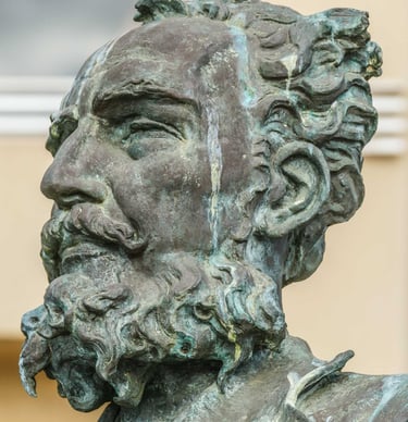 Bronze statue bust of a bearded man with curly hair and a mustache. Antonio Cano Cervantes
