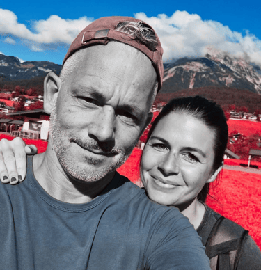 a man and woman taking a selfie in a red - hued photo