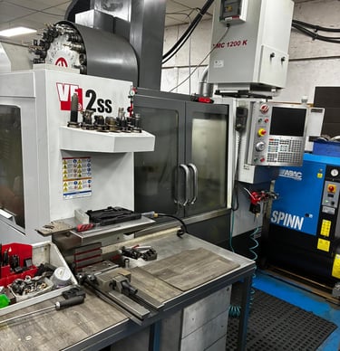 Haas VF-2ss CNC vertical machining center in a precision machine shop with industrial tooling and equipment.