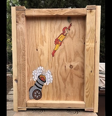 Shipping crate for Talbotics sculpture with image of human cannonball drawn on it.