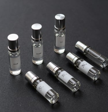 A stylish flat lay of niche cologne bottles alongside a leather wallet and watch, suggesting everyday luxury
