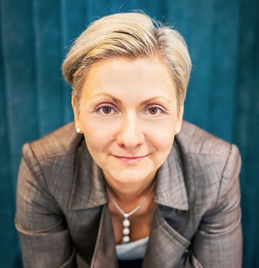 a woman in a suit and a necklace