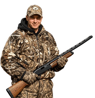 Guided hunting expert in camo gear holding a shotgun for Texas panhandle waterfowl and upland hunts