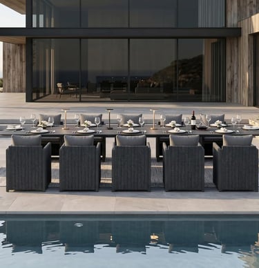 Modern outdoor dining set with long black table and gray wicker chairs by a luxury pool.