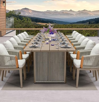 Luxury outdoor dining set with a long table and woven armchairs on a patio with mountain views.