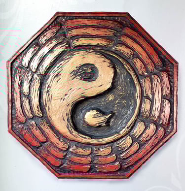 Picture of a Bague plaque. The yin-yang is in the center, surrounded by trigrams. It is red fading to gold in the center. 