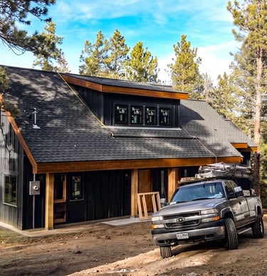 Modern detached garage with dark siding and wood trim built by Elk Valley Contractors in Evergreen, Colorado.