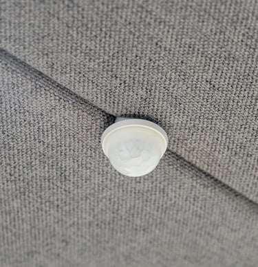 Built-in ceiling-mounted motion sensor on acoustic panel