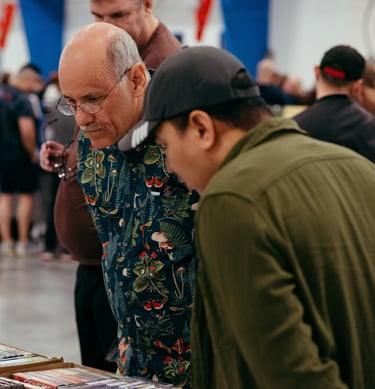 Two men look engaged and curious as they browse a selection of video games for sale.