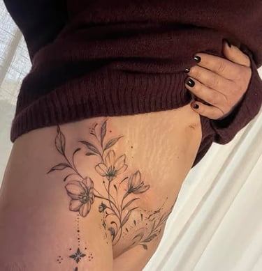 Une femme avec un tatouage sur sa cuisse sur cicatrice abdominoplastie montrant le côté de sa cuisse