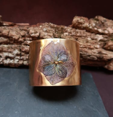 les bracelets styx manchettes dorés aspect magique, irréel, ornés de fleurs et de plumes