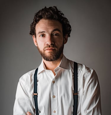 Portrait en studio homme qui croise les bras, en chemise et bretelles - book comédien - © Virginie Bouilhac